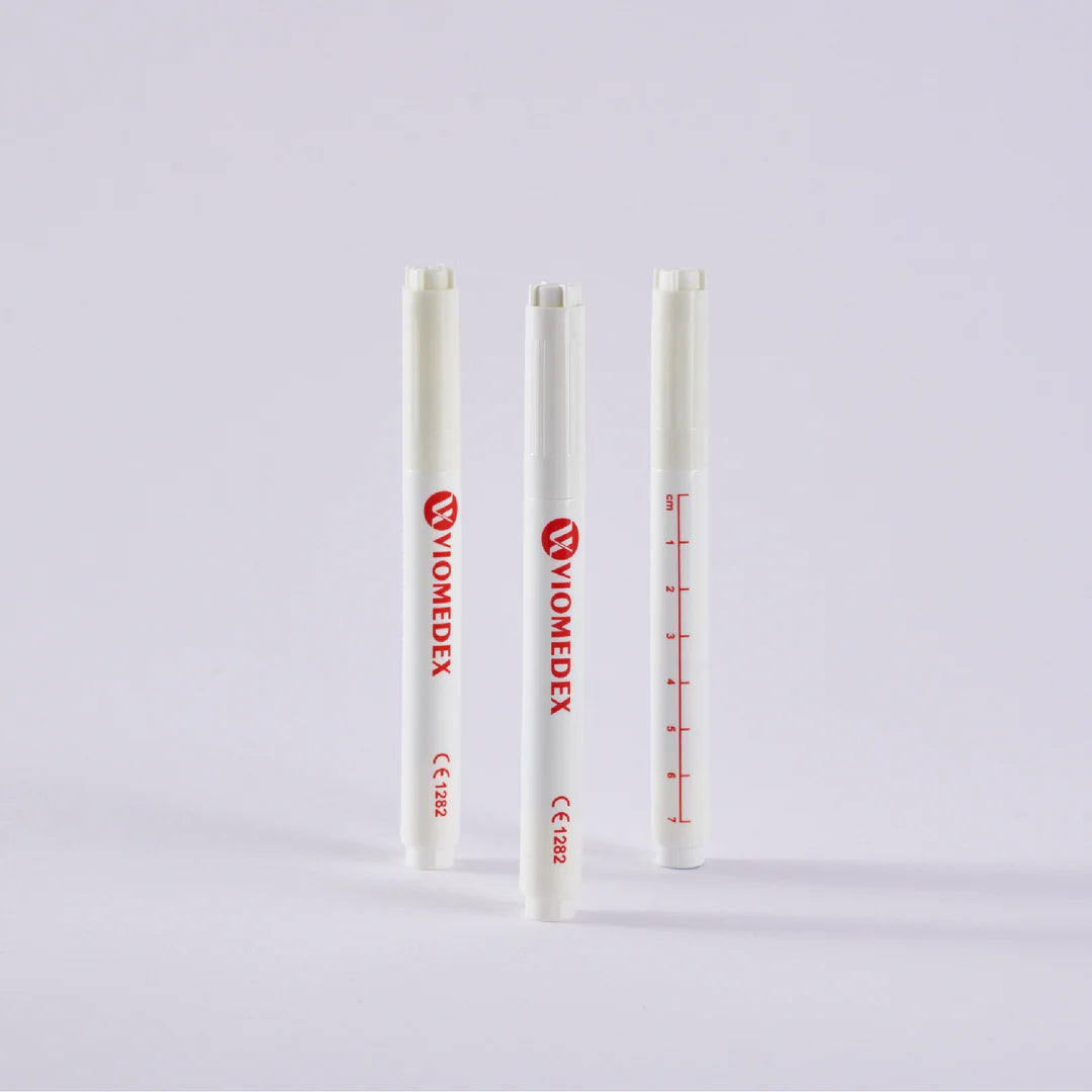 Three surgical skin marker pens with measuring scales printed on them, two with red markings and one with blue.