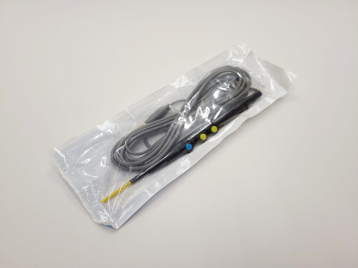 A black electrosurgical pencil with a yellow connector, sealed in a clear plastic bag.