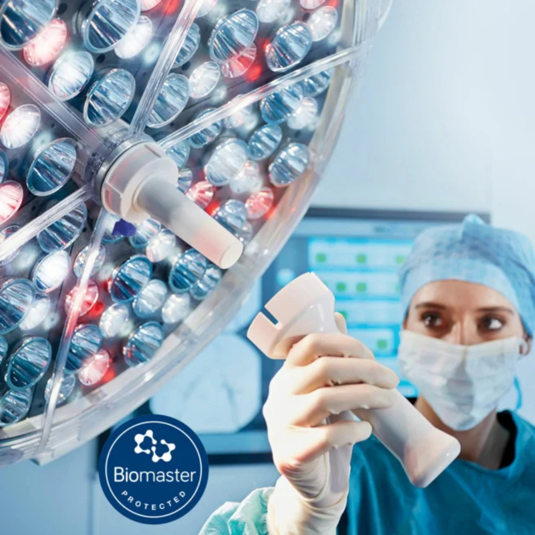 Person in a lab setting fitting a part to a surgery light 
