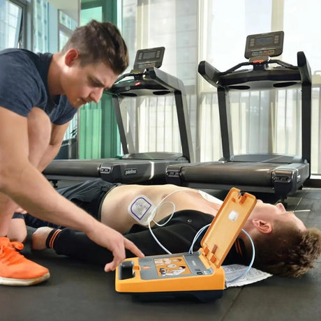 Person performing CPR on a someone with an Mindray Beneheart C1 AED Defibrillator in a gym setting